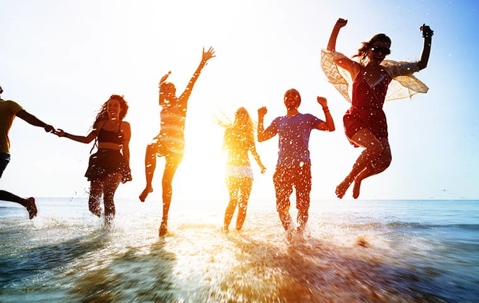 group of friends jumping out of a body of water