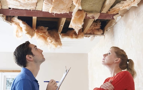 PCO inspecting ceiling of a room with a homeowner