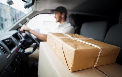 man driving with packages in the passenger seat of a vehicle